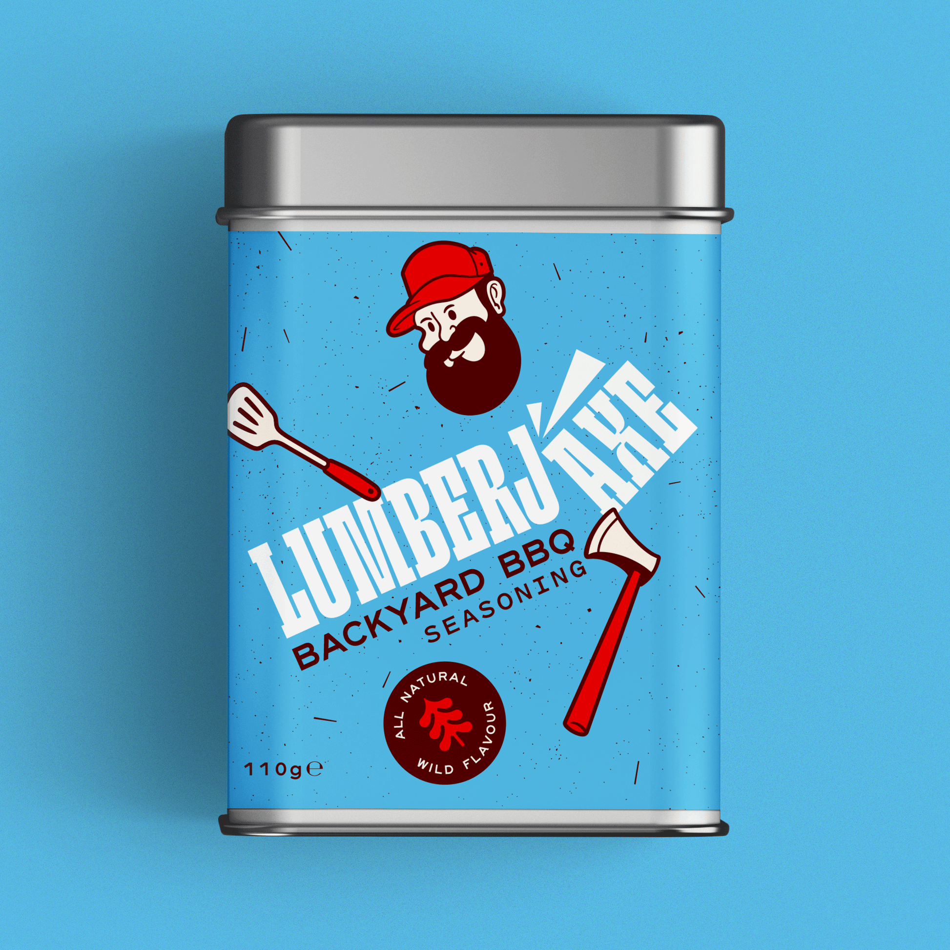 A tin container of 'Lumberjaxe Backyard BBQ Seasoning' displayed against a bright blue background. The tin has a speckled blue label featuring bold white typography with an axe graphic cutting through the text. The design includes a bearded lumberjack character in a red hat, illustrations of a barbecue spatula and an axe, and a red circular badge that reads 'All Natural Wild Flavour.' The seasoning weight is listed as 110g.