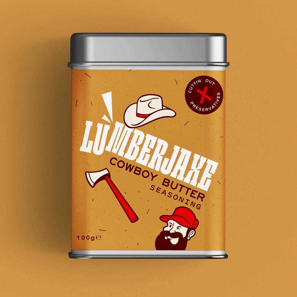 A tin container of 'Lumberjaxe Cowboy Butter Seasoning' displayed against a warm brown background. The tin has a speckled tan label featuring bold white typography with an axe graphic cutting through the text. The design includes a cowboy hat illustration, a red circular badge reading 'Cuttin' Out Preservatives,' a bearded lumberjack character in a red hat, and an axe. The seasoning weight is listed as 100g.